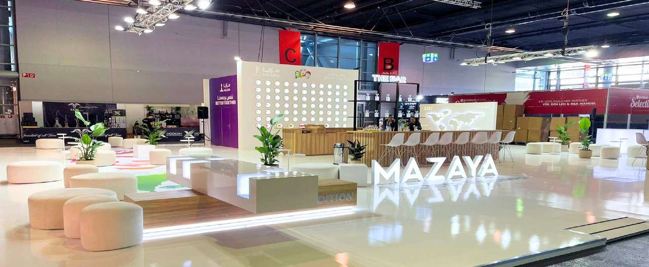 Mazaya hospitality stand with lounge seating, illuminated brand letters and a central bar at InterTabac in Dortmund